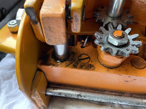 Zbliżenie na mechanizm hamulcowy przyczepy z widocznymi elementami ciernymi.