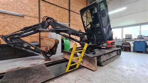 technik serwisu JCB dokonujący diagnostyki maszyny za pomocą laptopa