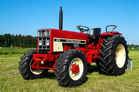 Infografika porównująca wymiary zewnętrzne ciągnika International Harvester 633 z typową przyczepą rolniczą