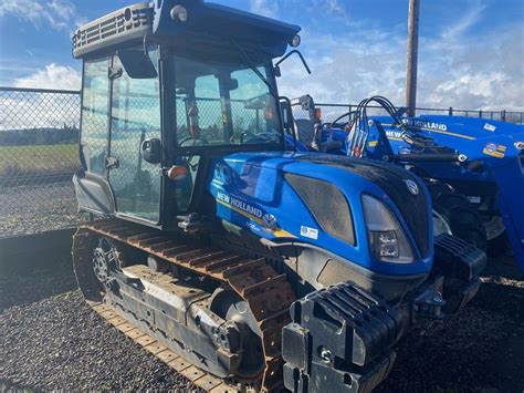 Zdjęcie ciągnika New Holland TK4.100 M ze stalowymi gąsienicami.