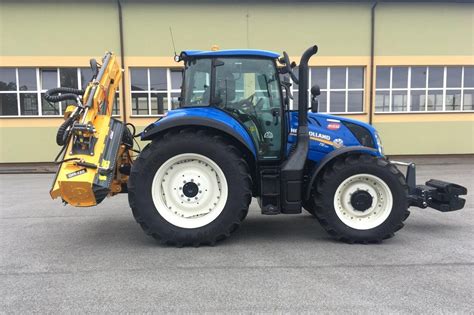 zdjęcie ciągnika New Holland serii T5/T6/T7 z podłączoną kosiarką wysięgnikową
