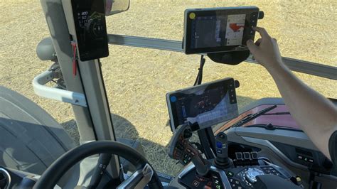 Ilustracja przedstawiająca panel sterowania ISOBUS w kabinie ciągnika, podłączony do rozsiewacza Kverneland