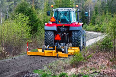 Photo of a towed grader attached to an agricultural tractor