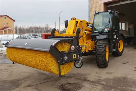 Zamiatarka z pojemnikiem podłączona do ładowarki JCB, zbierająca odpady
