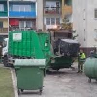 Tematyczne zdjęcie ładowacza nieczystości stałych przy pracy ze śmieciarką