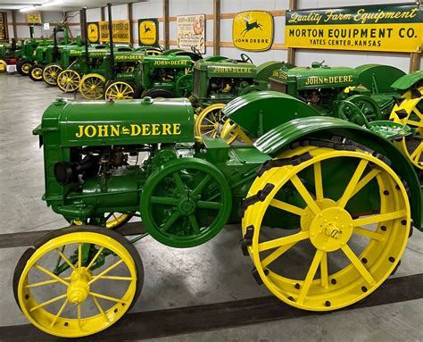 zdjęcie przedstawiające różne modele traktorków John Deere zaparkowane w okolicy miasta