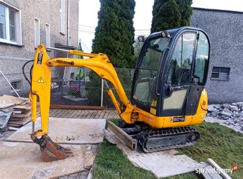 Wnętrze kabiny operatora minikoparki z wygodnym fotelem i panelem sterowania