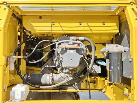 Lokalizacja zaworu sterującego i zatyczki kontrolnej na koparce Komatsu PW240