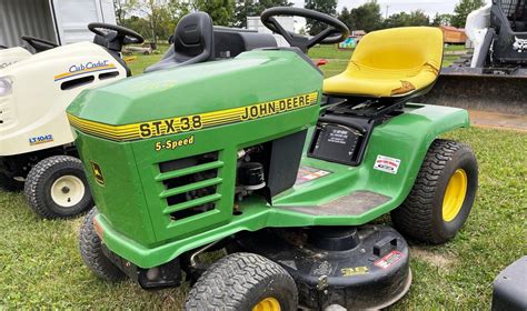 John Deere STX 38 na tle ogrodu
