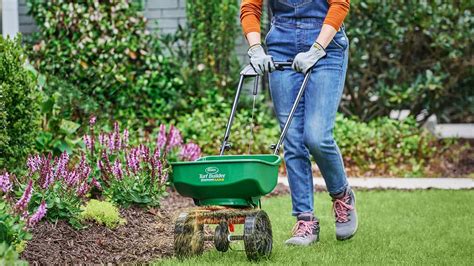 Thematic photo of a person using a lawn spreader.