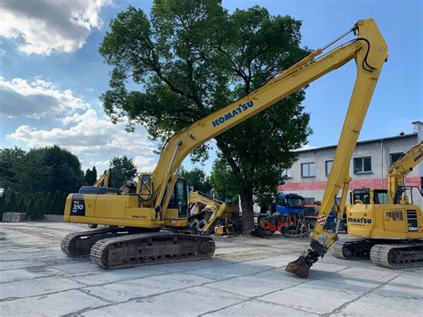 Koparka Komatsu wykonująca niwelację terenu z użyciem pływającej łyżki