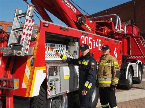 Strażacy używający sprzętu hydraulicznego do podnoszenia ciągnika