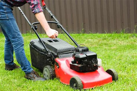 Thematic photo of a person starting a lawn mower with a pull starter