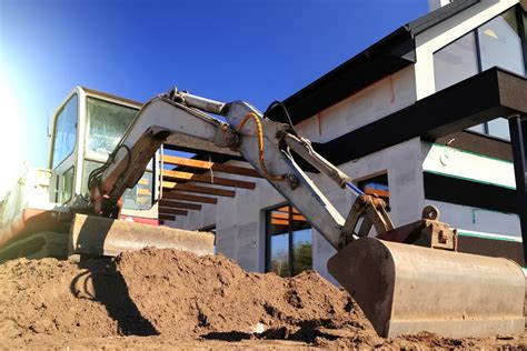Zespół mechaników serwisujących maszynę budowlaną w terenie