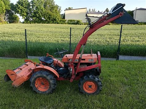 zdjęcie nowoczesnego ciągnika Kubota L2 z osprzętem do utrzymania dróg
