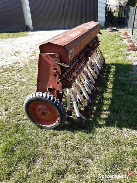 Zbliżenie na elementy mechaniczne siewnika Poznaniak, takie jak redlice lub przekładnia olejowa
