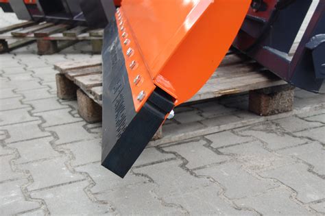 Zdjęcie zbliżenia na różnego rodzaju osprzęt do ładowaczy czołowych, np. łyżka krokodyl, chwytak do bel