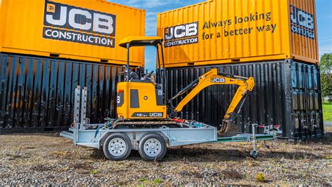 Photo of a mini excavator being transported on a dedicated trailer.
