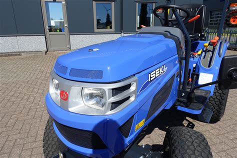 Widok na nowoczesny traktor Iseki TM 3267 w pracy na tle krajobrazu