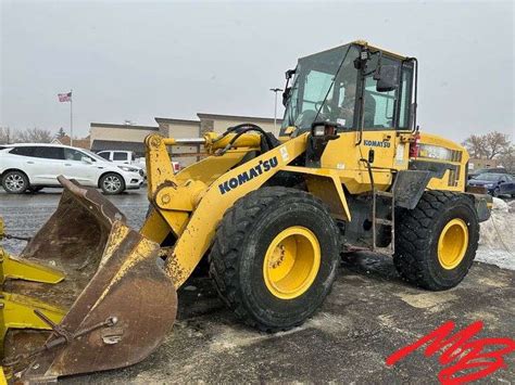 Schematyczny widok ładowarki kołowej Komatsu WA 250 z zaznaczonymi kluczowymi elementami