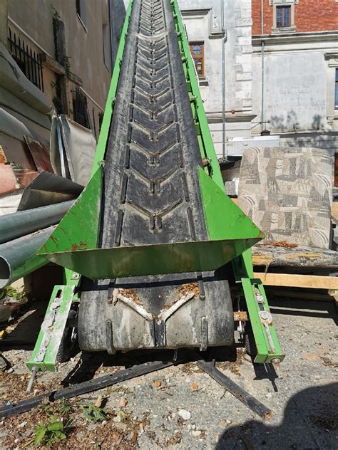 Podłogowy podajnik taśmowy w rozsiewaczu REWO