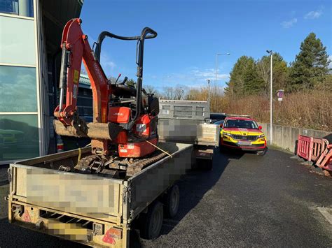Photo of a miniexcavator improperly secured on a delivery van