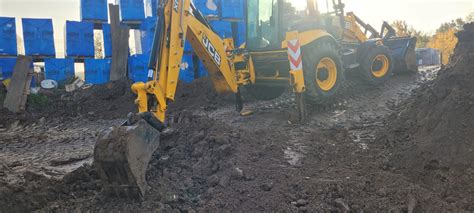 Tematyczne zdjęcie dużej koparko-ładowarki w akcji na placu budowy