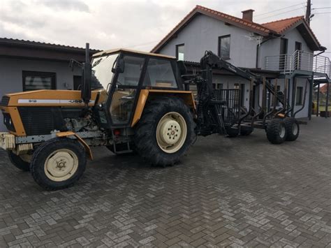 Ciągnik rolniczy z wózkiem do zrywki drewna w akcji