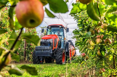zdjęcie ciągnika Kubota M7040N pracującego w sadzie