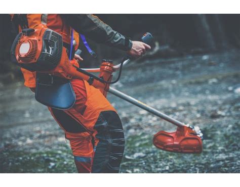 Zdjęcie przedstawiające wykaszarkę spalinową Husqvarna w akcji na zarośniętym terenie