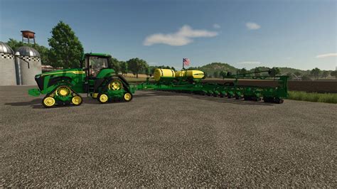 Tematyczne zdjęcie z gry Farming Simulator 19 przedstawiające traktor z siewnikiem i nawozem.