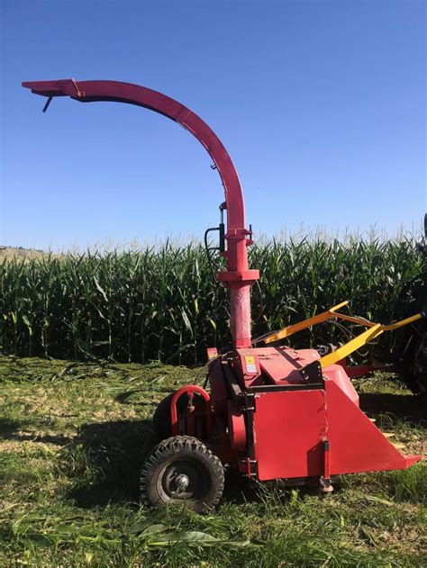 Thematic photo of a single-row corn chopper attached to a tractor in a field