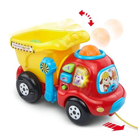 The Vtech Smart Dump Truck toy with a green cabin and orange trailer, featuring educational blocks being inserted into its chute.