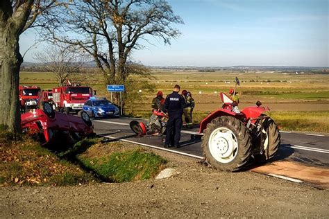 Zdjęcie przewróconego ciągnika rolniczego na polu, służby ratunkowe