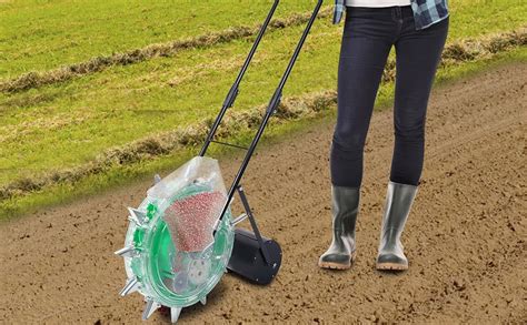 Thematic photo of a person using a hand-cranked seeder in a garden for sowing seeds or spreading fertilizer.