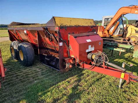 Photo comparing a single-axle manure spreader and a double-axle (tandem) manure spreader
