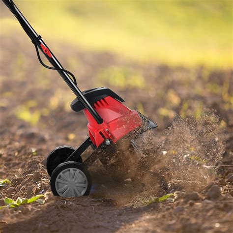 Close-up of the rotating blades of an electric tiller breaking up soil