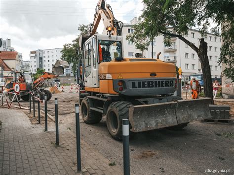 Ilustracja przedstawiająca ciągnik wykonujący prace drogowe z włączonym światłem ostrzegawczym