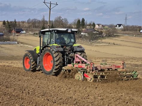 Ciągnik z podłączoną dużą broną talerzową podczas pracy