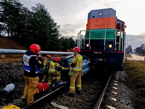 Ilustracja dwudrożnego ciągnika szynowo-drogowego pracującego na torach kolejowych i drodze