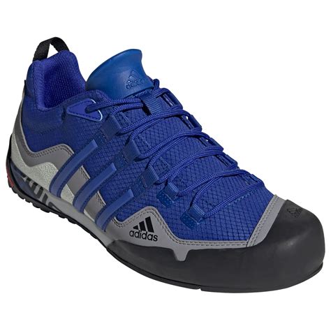 Graficzne przedstawienie modelu Adidas Terrex Swift Solo z zaznaczeniem kluczowych elementów cholewki i podeszwy.