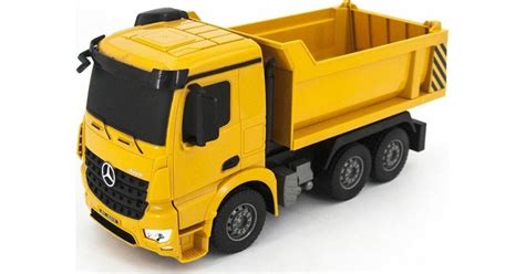 Zdjęcie dużej żółtej wywrotki Mercedes-Benz Arocs z pilotem w ręku dziecka
