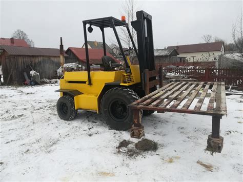 Zdjęcie przedstawiające wózek widłowy terenowy z zamontowanym dodatkowym osprzętem.