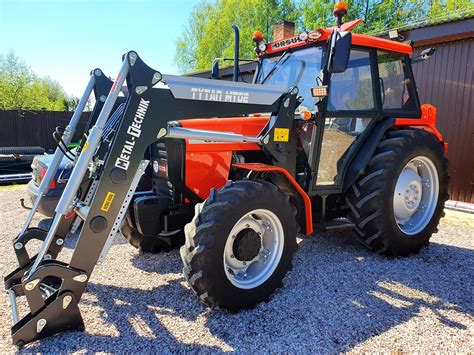 Ursus 4514 z zamontowanymi widłami, wykonujący prace polowe