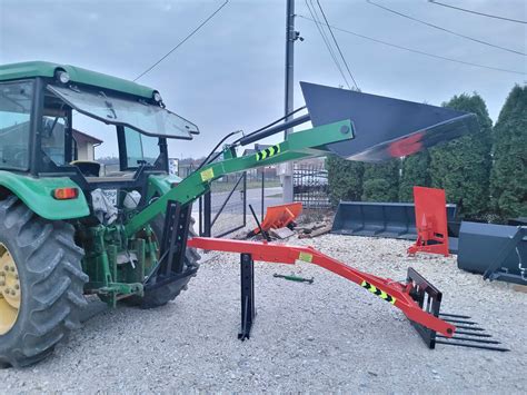Ładowacz tylny z belami siana na ciągniku w trudnym terenie
