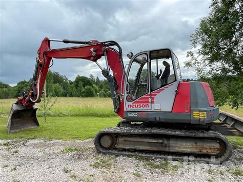 Schemat techniczny koparki gąsienicowej Neuson 12002 prezentujący zasięg ramienia i wymiary maszyny