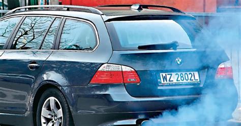 zdjęcie kosiarki wydobywającej niebieski dym z wydechu