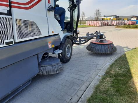 zamiatarka drogowa z widoczną szczotką boczną w akcji