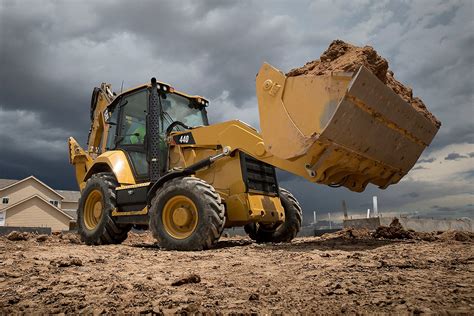 Thematic photo of a modern Caterpillar backhoe loader in action on a construction site