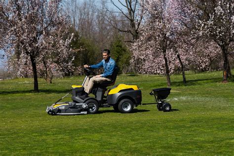 Mały, wielofunkcyjny traktorek w pracy w ogrodzie